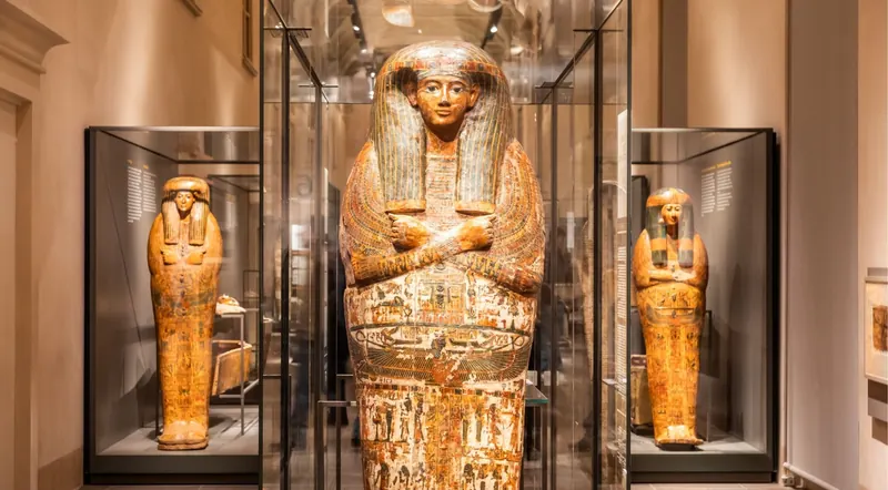 Sarcophagi and ancient Egyptian statues on display inside the Grand Egyptian Museum